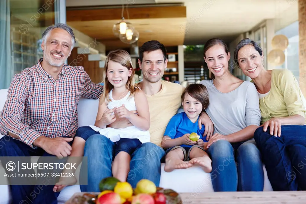 Theyre happiest when theyre all together. A portrait of a happy multi-generational family gathered at home in their living room.