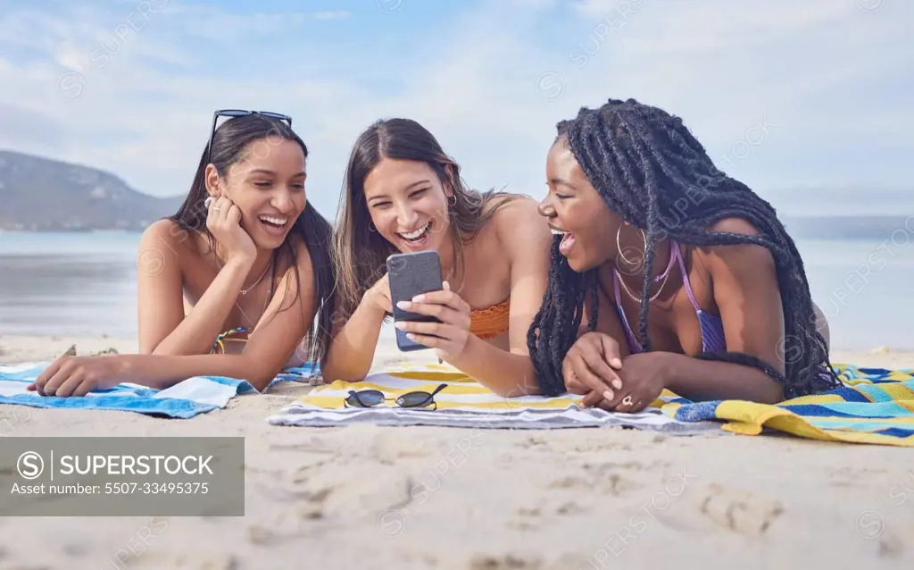 Girl friends, beach and phone of a teenager laughing at funny meme by the sea in Miami. Travel, vacation and sunshine with happy students enjoying spring break with mobile connection lying on sand