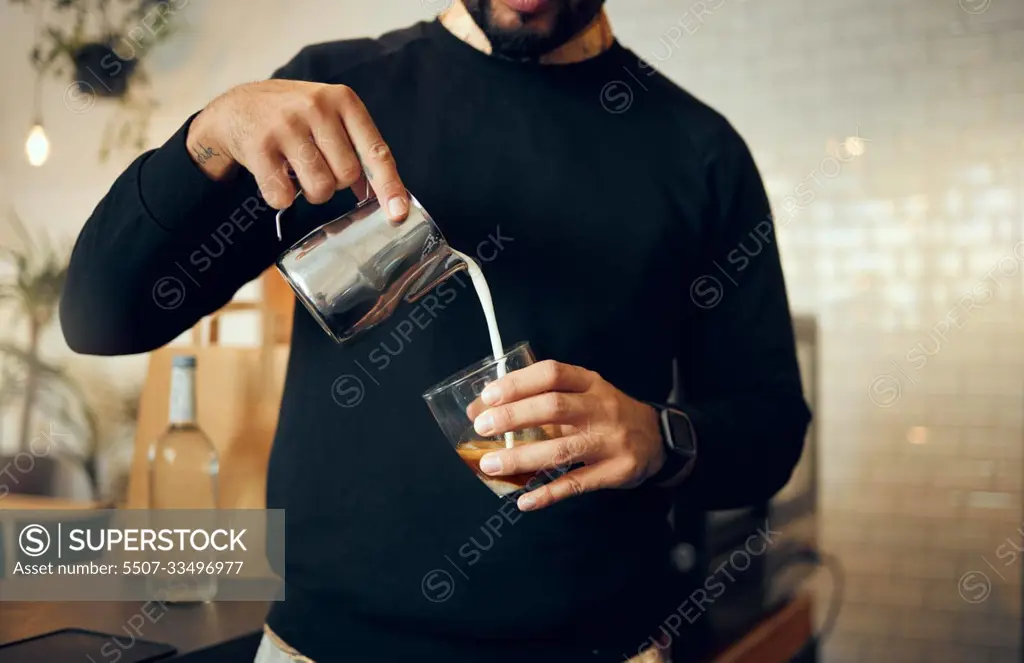 Coffee, milk and hands of man in cafe for cappuccino, breakfast and caffeine beverage. Relax, espresso and dairy with barista in coffee shop and with latte for retail, mocha and drink preparation