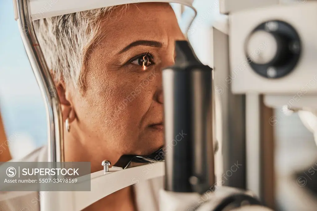 Medical, ophthalmology and eye test by patient senior woman with medical insurance using slit lamp. Mature, optometry and female doing vision or eyesight test in clinic using a machine