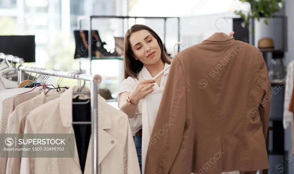 Shopping, retail and a woman customer in a mall boutique to buy trendy clothes for seasonal fashion. Search, store and sale with a young female consumer in a shop, making a clothing purchase choice