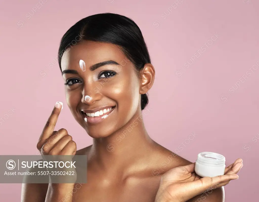 Skincare, face and woman with cream container in studio isolated on a pink  background. Product, dermatology creme and portrait of happy Indian female  model apply lotion, moisturizer and cosmetics. - SuperStock