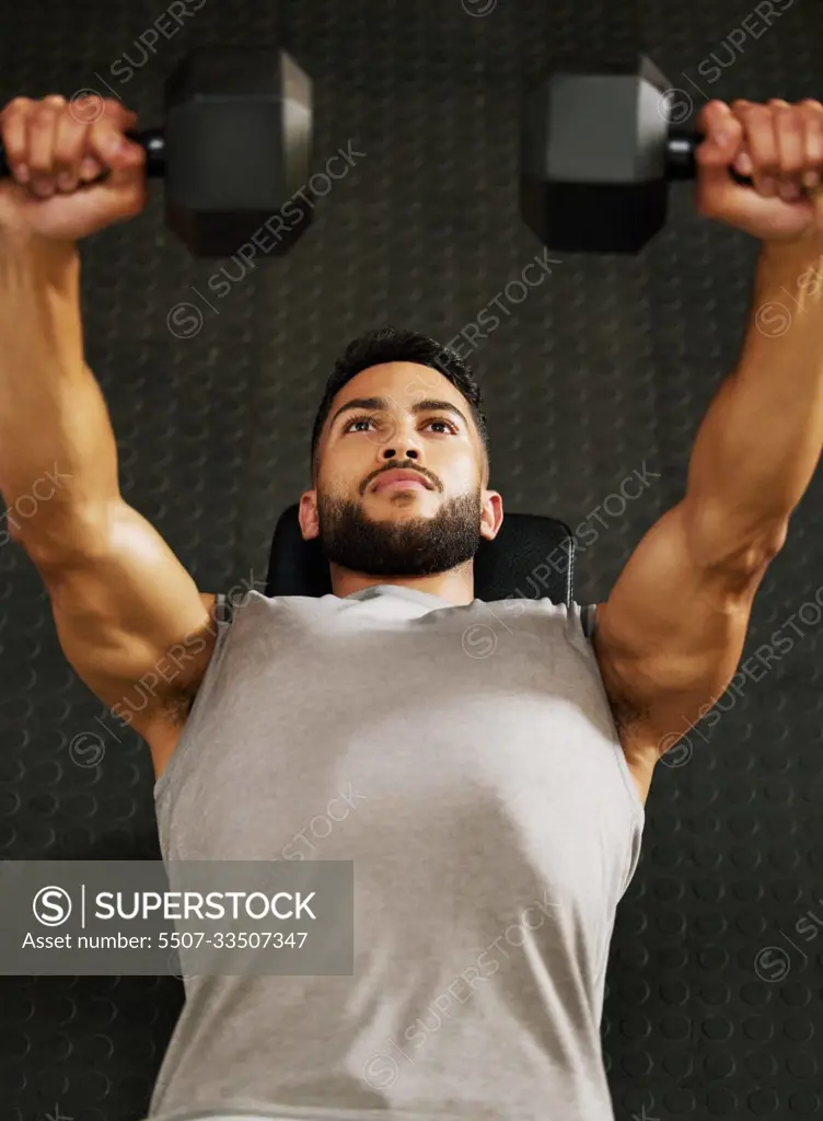 Bench press, fitness and man with weights in gym for exercise, bodybuilder training and workout. Sports, strong muscle and serious male person lifting weight for wellness, healthy body and strength