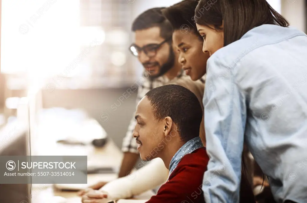 Theyre all wanting the best for their education. a group of university students working together on a computer in the library on campus.