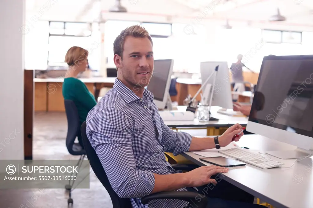 Hard at work. a handsome young man working in his office.