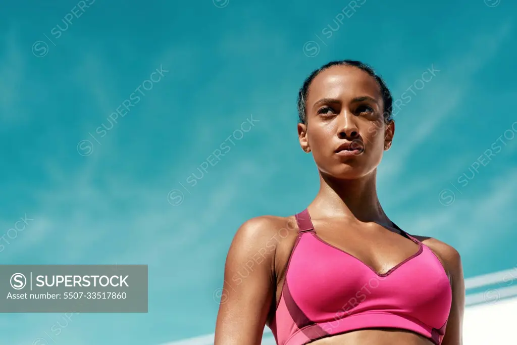 Sports, fitness and serious woman with blue sky mockup at outdoor gym for health and wellness. Workout, exercise and female athlete with focus, power and healthy mindset for summer goals with space.