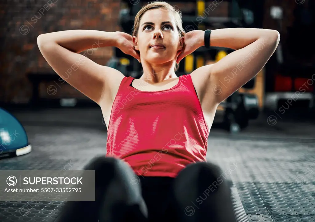 Core strength. an attractive young female athlete doing situps in the gym.