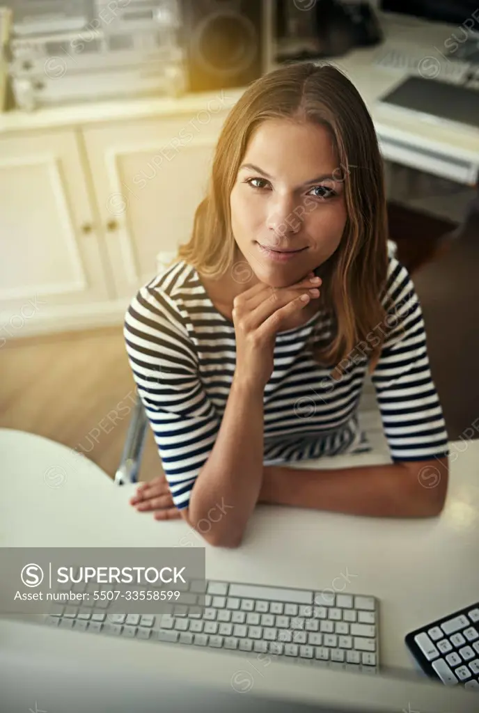 Working from my home office. High angle portrait of a young woman working on a computer in her home office.