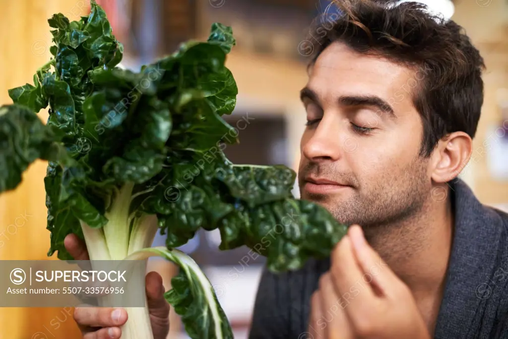 These seem fresh. a young man choosing which spinach to buy.