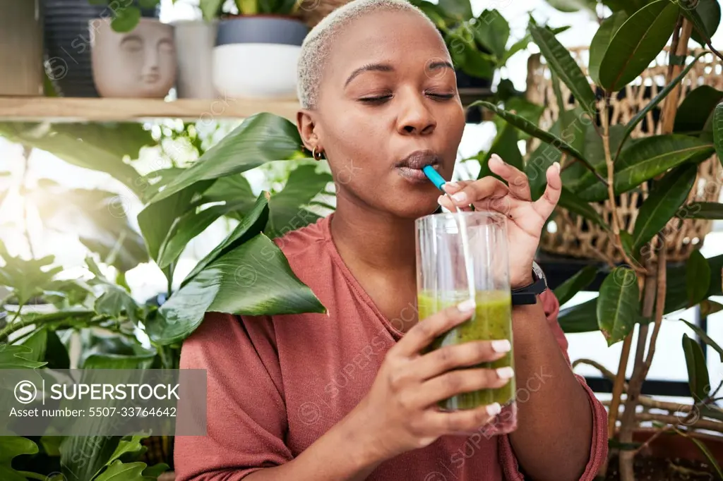 Nutrition, drinking and black girl with green smoothie for diet with plants for wellness or weightloss. Healthy, woman and enjoy a detox drink with vegetables for vitamins with supplement in home.