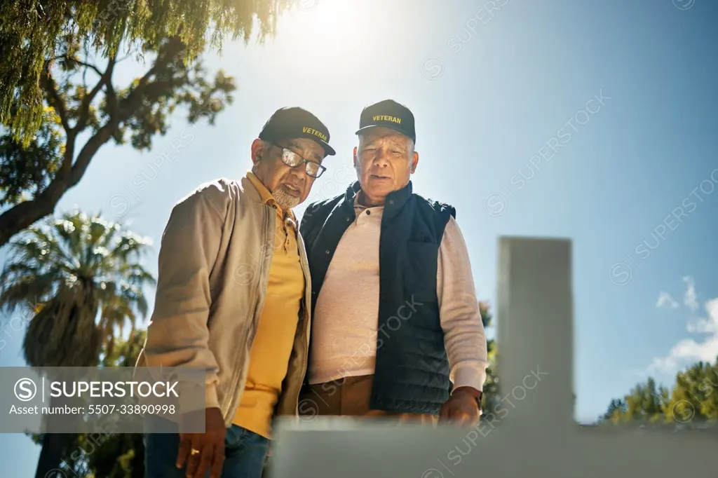 Senior veteran men, tombstone and respect for military, navy or memorial in cemetery for grief, support or empathy. Elderly friends, gravestone and together with thinking, memory and love for soldier