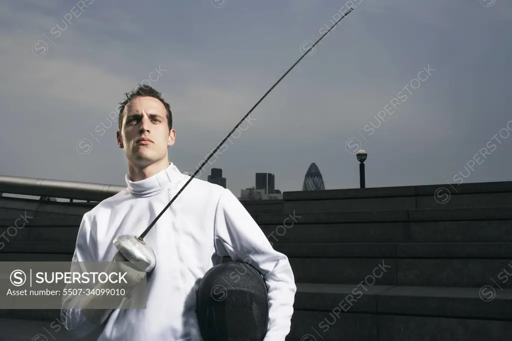 Fencer holding sword outdoors portrait