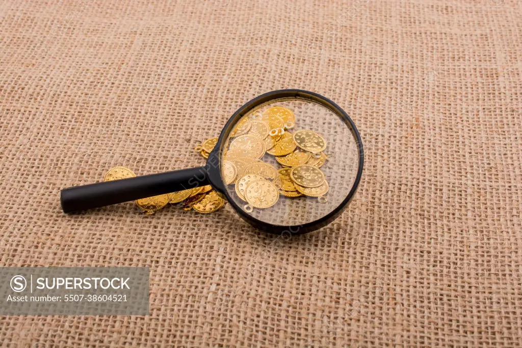 Magnifying glass and plenty of fake gold coins