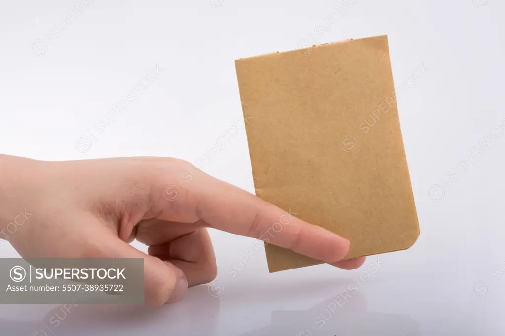 Hand holding a brown color paper