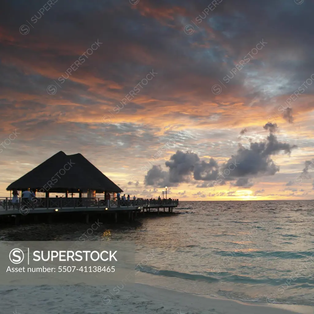 Beach and tropical houses on sunset