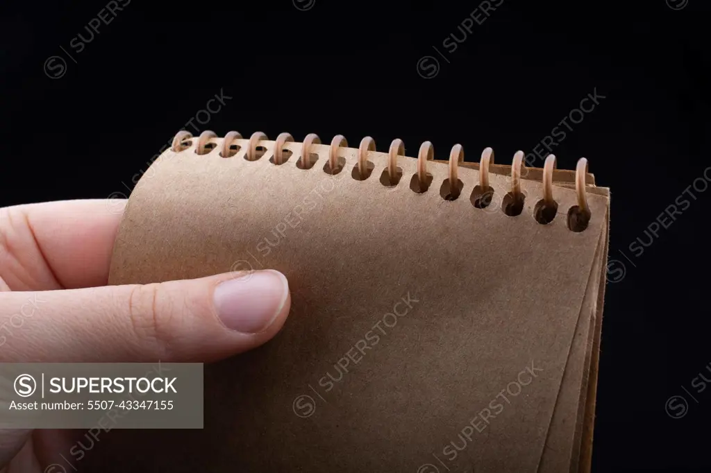 Notebook  in hand on a black color background