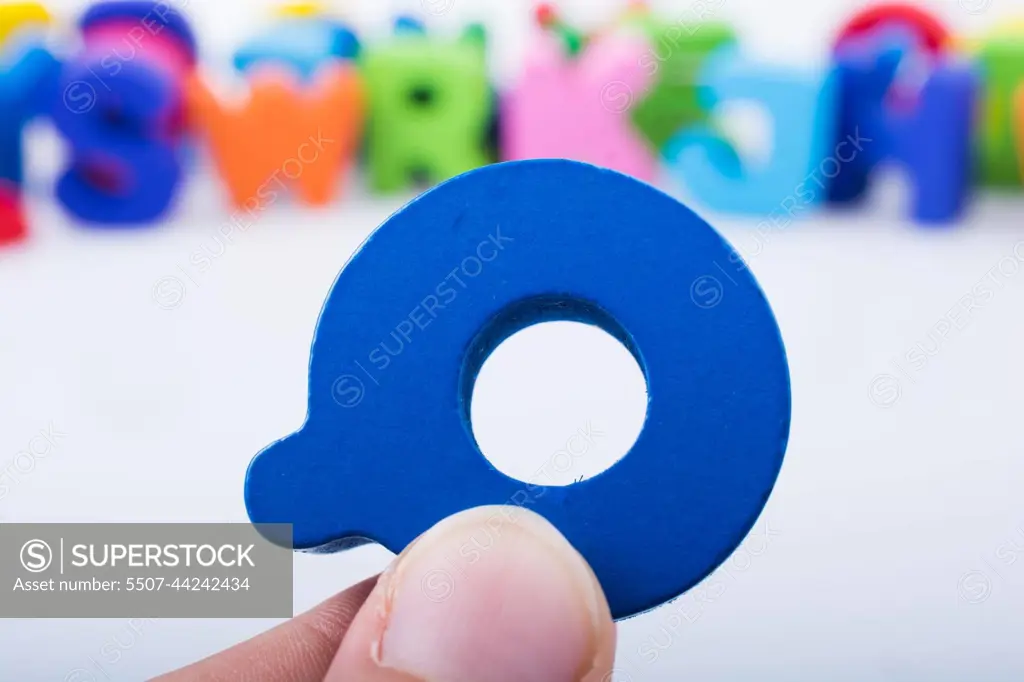 Hand holding Letter cube  Q of  Alphabet