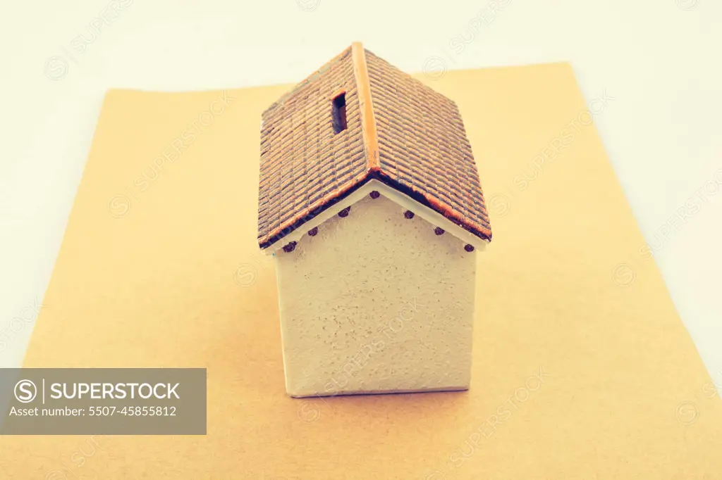 Little model house with a sign board in view