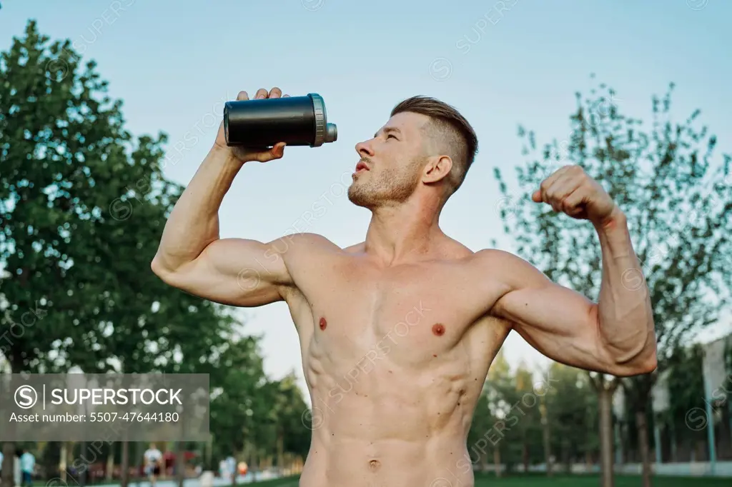 sports muscular man in the park healthy food fitness