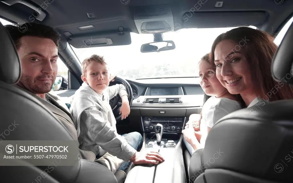 cheerful family sitting in the car