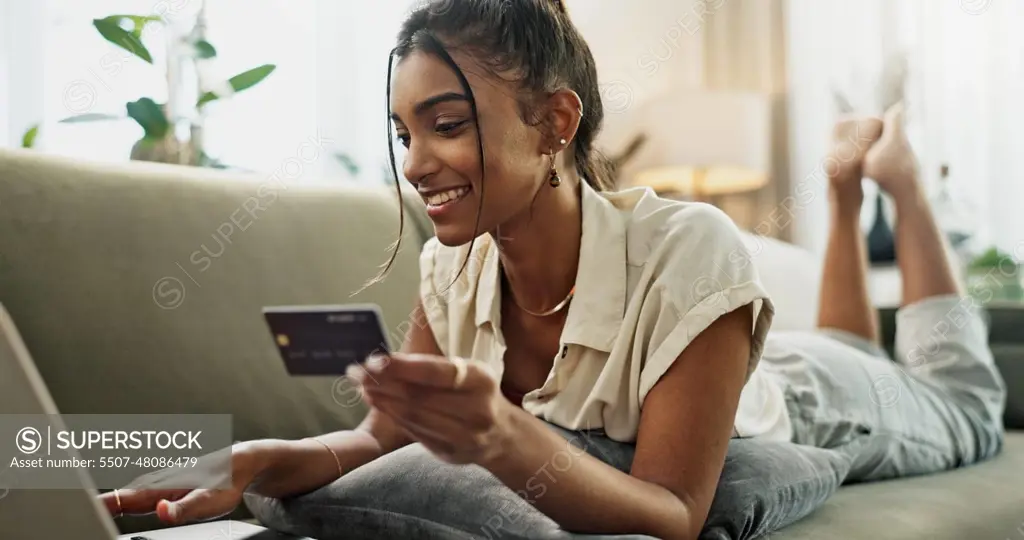 Credit Card, laptop and happy woman relax, online shopping and check account balance, sales promotion or bank value. Digital money exchange, easy payment or Indian customer buying on home lounge sofa