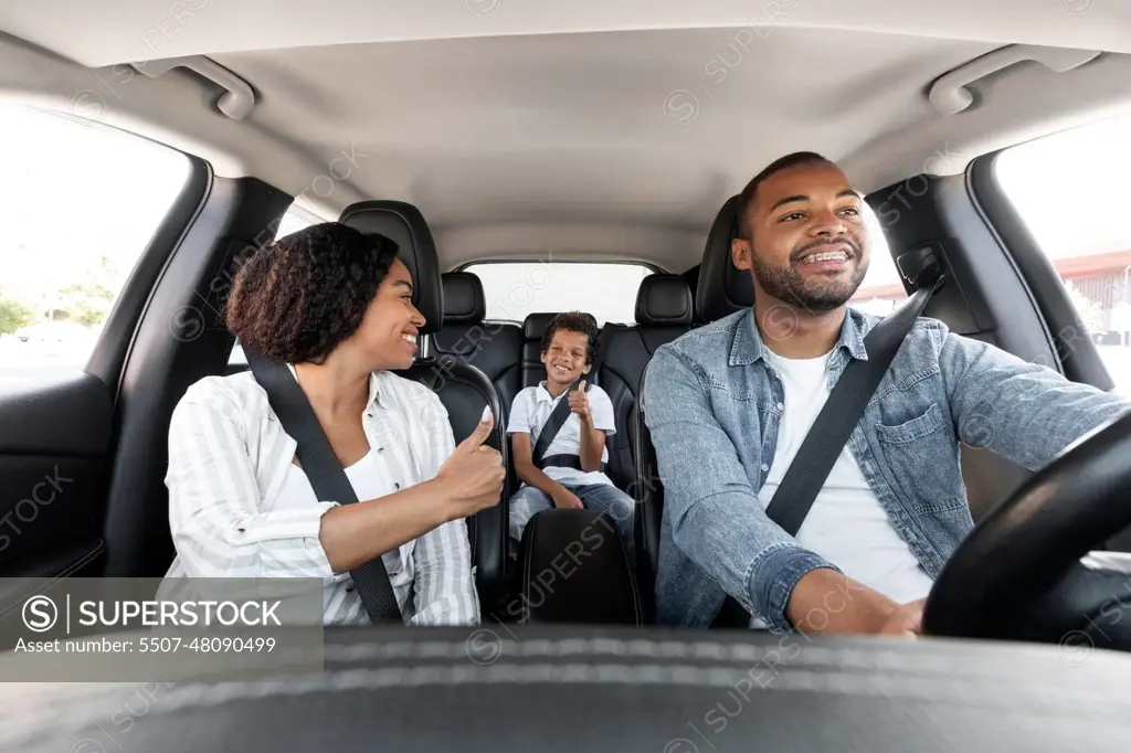 Happy black family enjoying car ride together