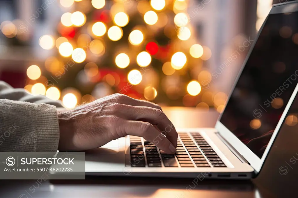 a person typing on a laptop computer with christmas