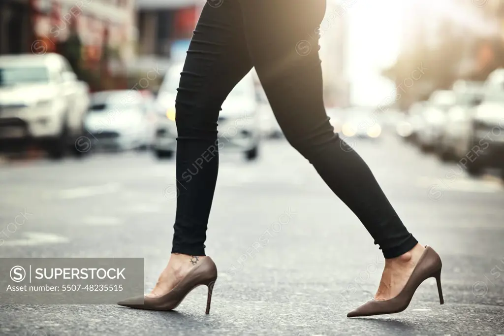 High heels, business and woman crossing the street closeup in a city on her commute to work. Feet, fashion and a female employee walking on an asphalt road in an urban town for a professional career