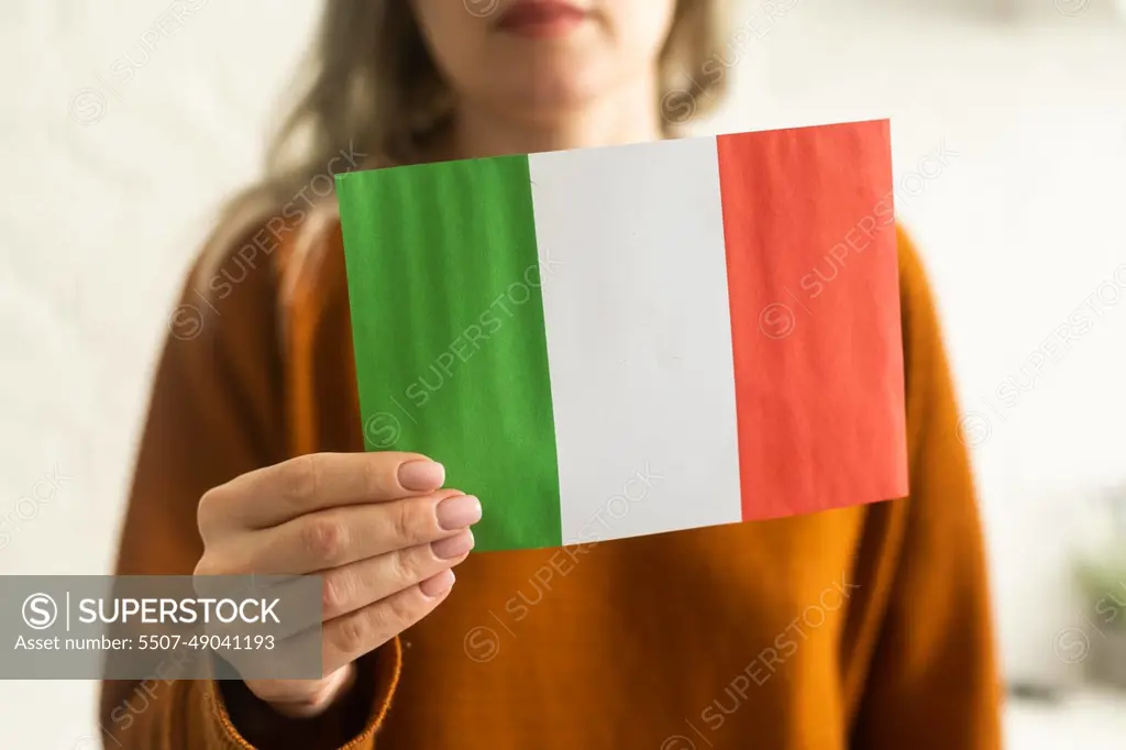 Person holding a Italian flag on a white background