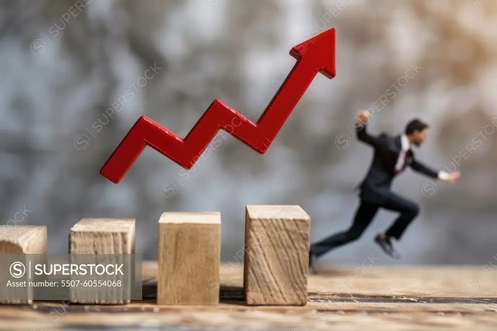 A man is running up a wooden staircase with a red arrow pointing upwards. Concept of progress and achievement, as the man is reaching for a higher goal