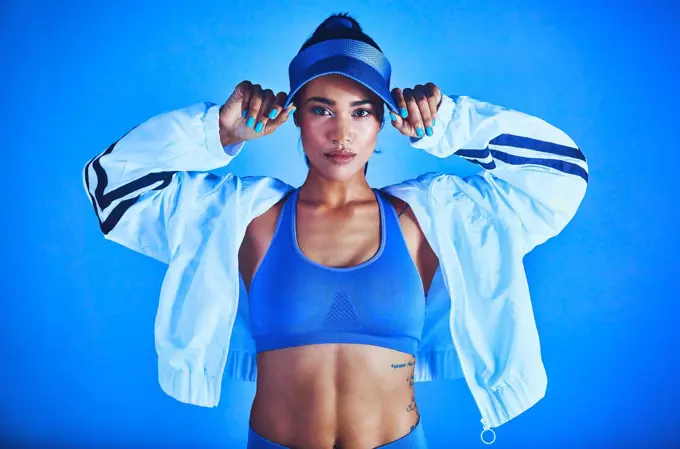 I'm dressed to give my best. Cropped portrait of an attractive young female athlete posing against a blue background.