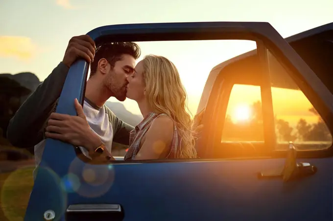 Stopping for a smooch. Shot of an affectionate young couple on a roadtrip.