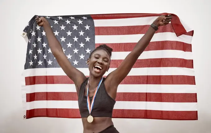 You can congratulate me now. Shot of a young female athlete celebrating her win while running with a flag.