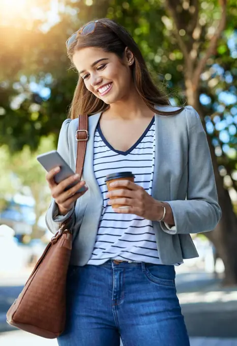 Im on the way. Cropped shot of an attractive young woman using her cellphone while commuting to work.