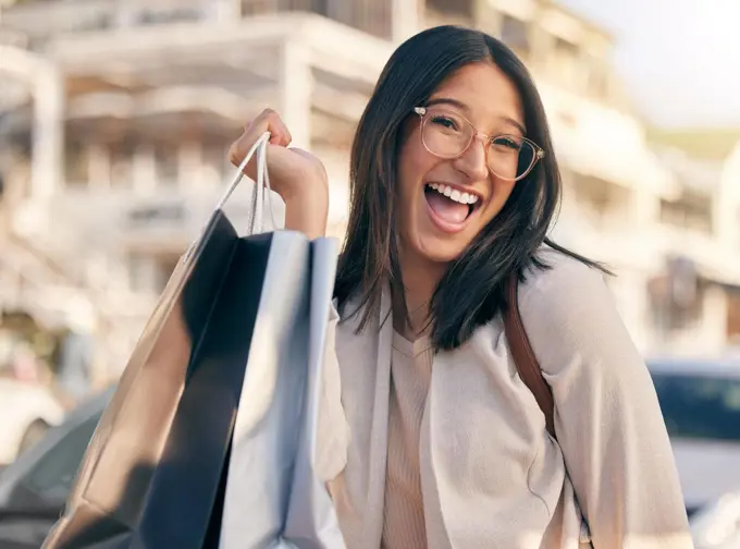 Best buys of the season. Portrait of an attractive young woman walking alone outside while shopping in the city.