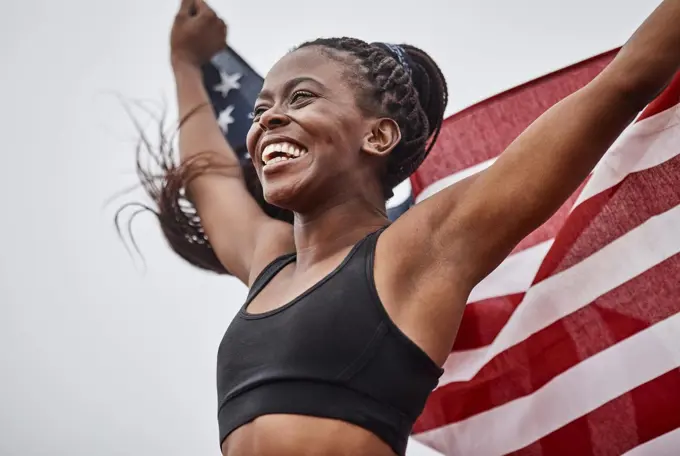 The training was worth it. Shot of a young female athlete holding a flag.