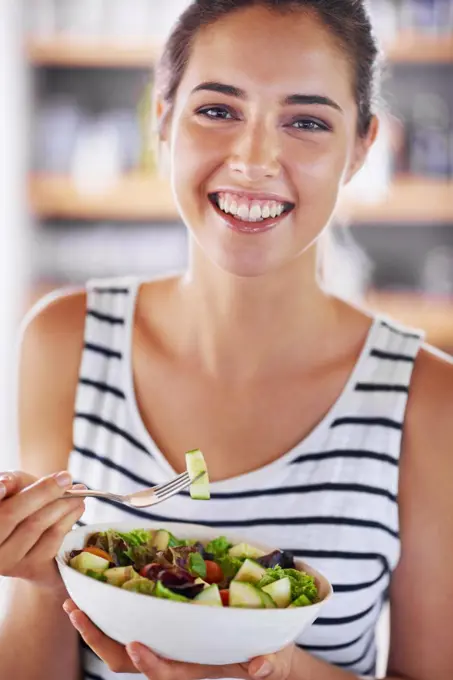 Enjoying a healthy snack. Cropped shot of a beautiful young woman at home.