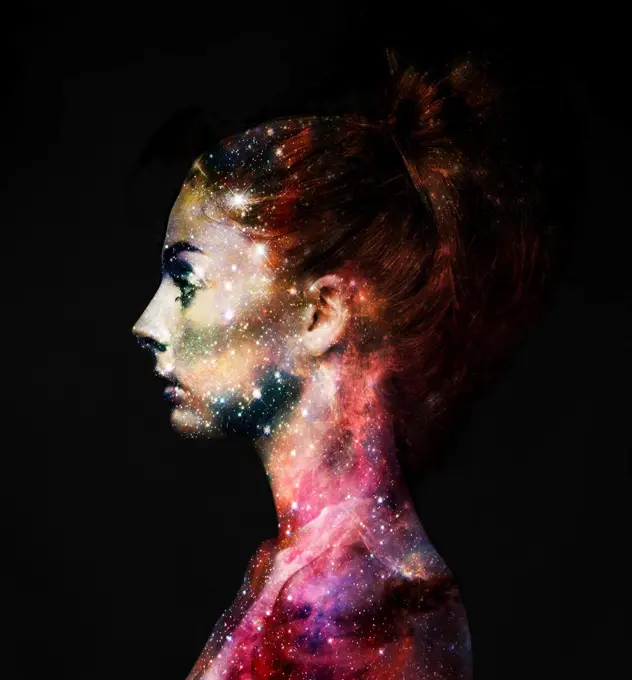 Intergalactic beauty. Profile of a young woman with the galaxy overlaid on her face.