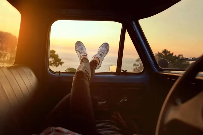 Roadtrip chill. Cropped shot of an unrecognizable woman lying in a car during a roadtrip.