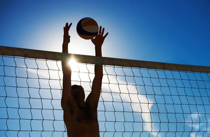 Denied. Shot of a beach volleyball game on a sunny day.