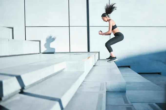 Taking it one step at a time. Full length shot of an attractive young female athlete exercising outside in the city.