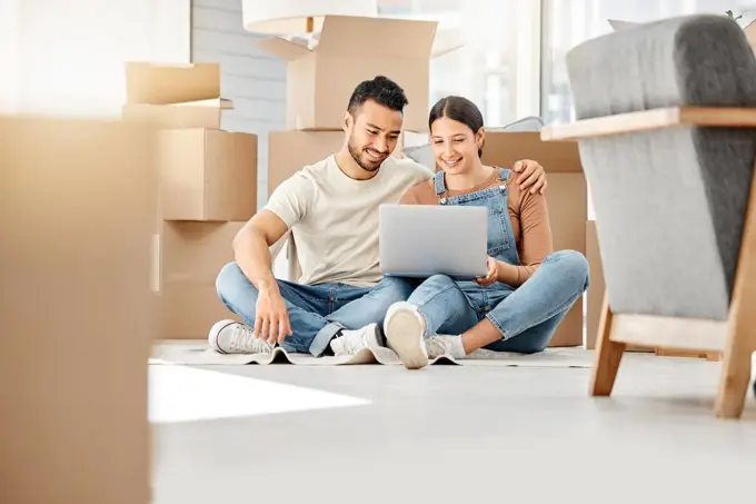 Lets see what furniture we can buy online. Shot of a young couple using a laptop while moving house.