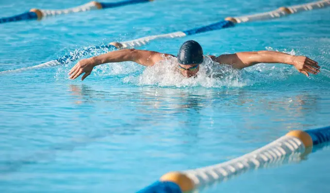 Lap after lap. a handsome young male athlete swimming in an olympic-sized pool.