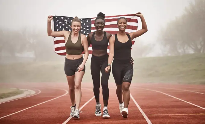 Marching our way to victory. a young sports team holding the american flag.