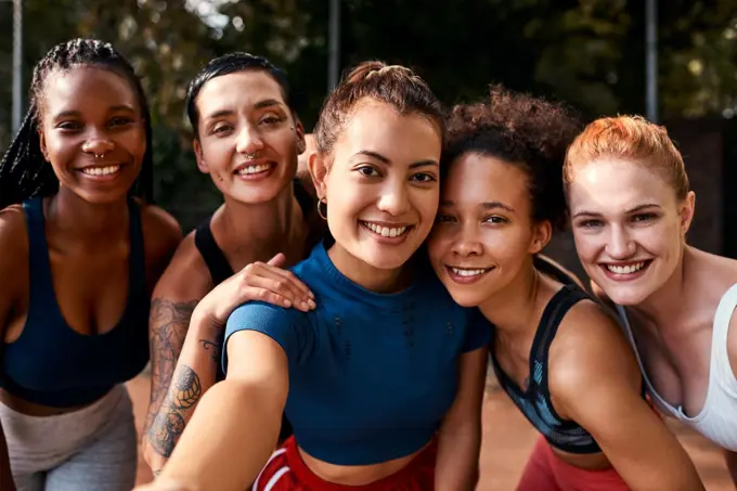 I couldnt have chosen better friends. a diverse group of sportswomen bonding after a basketball game together during the day.