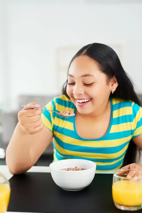 For a healthy start, have a healthy breakfast. a happy young girl enjoying a healthy breakfast at home.