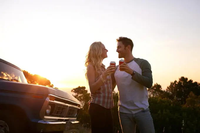 Heres to an amazing roadtrip. an affectionate young couple on a roadtrip.