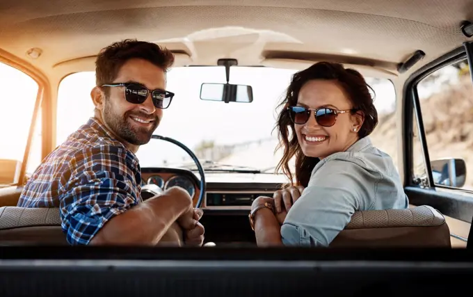 Youll never regret a road trip. Rearview portrait of an affectionate couple enjoying a summer road trip.