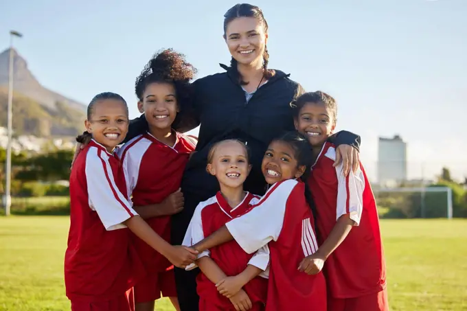 Football, happy and girl team with coach on a sport soccer field after training or a game. Teamwork and collaboration with a happy group of female athletes play for fun, to win and succeed