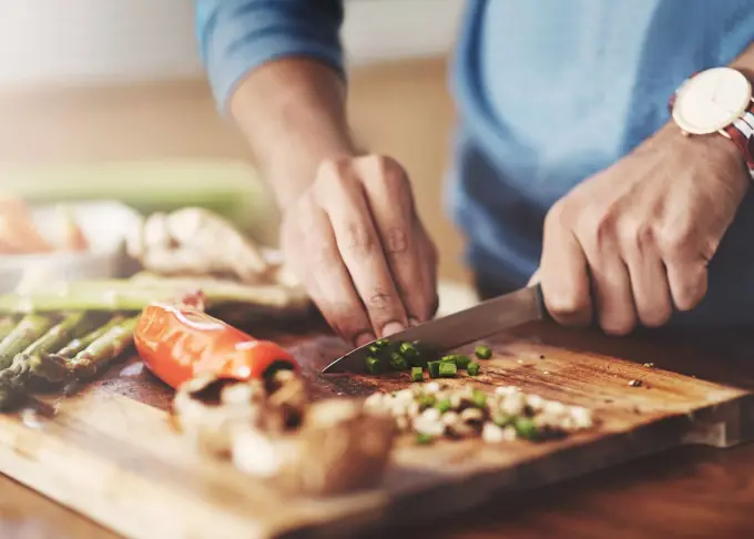 Taking a slice out of the healthy life. a man preparing a healthy meal at home.